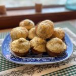 Blue and white plate on table with green cloth of muffins on plate